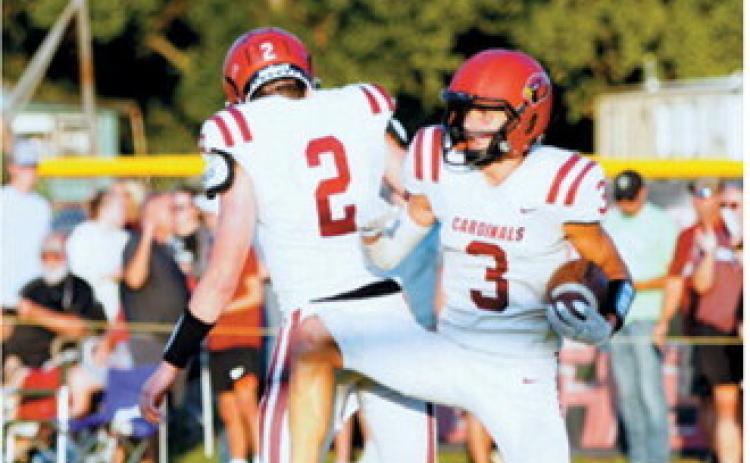 Langdon Area-Munich’s TJ Henderson, No. 3, celebrates with teammate Eastyn Schaefer, No. 2, during the Cardinals’ game against the Oakes Tornadoes on Friday, Aug. 21, in Oakes. Photo by Larry Stokke