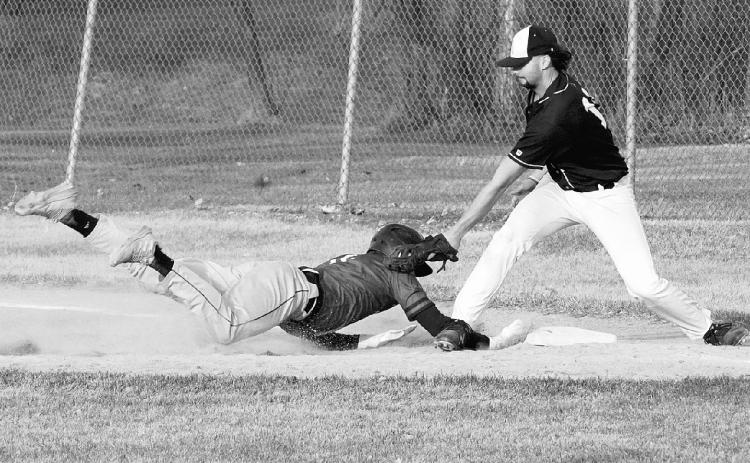 Kadyn Hein dives back safely to first base against Park River. Photo by Larry Stokke.
