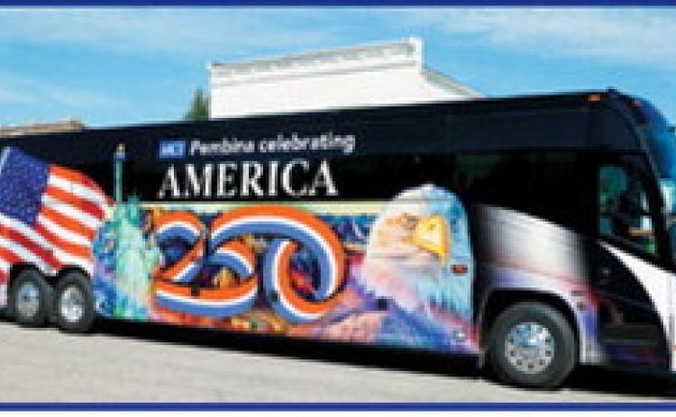 Motor Coach Industries' patriotic coach bus rolls through Pembina during the community's Fourth of July parade. The bus, wrapped in an America 250-themed design featuring patriotic imagery, helped celebrate the nation's upcoming 250th birthday while showcasing Pembina's role in the nationwide commemoration. Photo by Larry Stokke