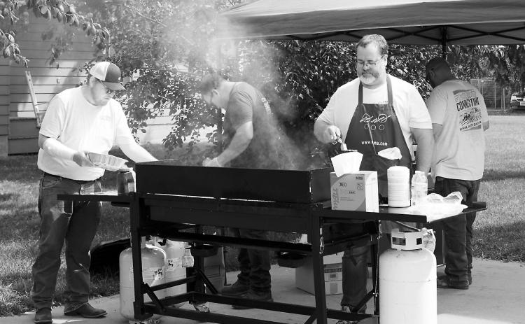 United Communications workers attending to the grill at their free luncheon last week. Photo by Larry Stokke.