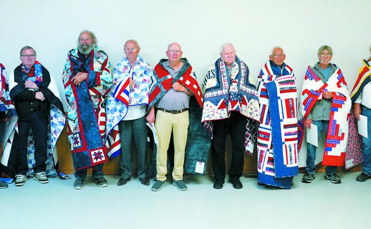Quilts of Valor recipients (L-R) Fred Domres, Emeric Boesl, David Chaput, Rick Crockett, Richard Rose, Francis Hoffarth, Dennis Metzger, Terry Howatt, and Robert Becker. Photo by Larry Stokke.