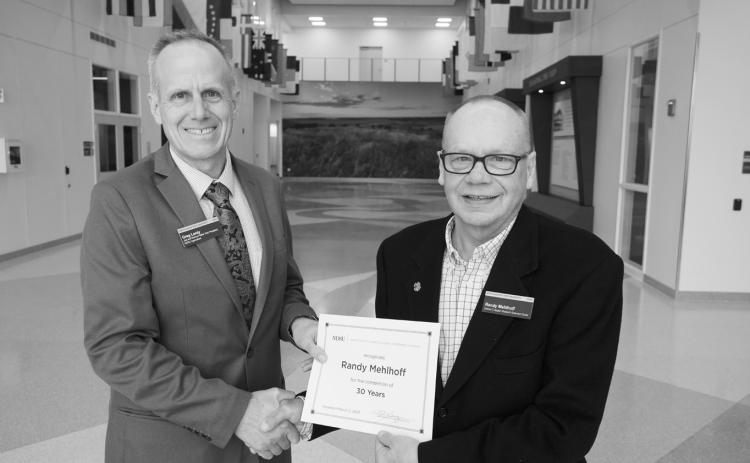 Randy Mehlhoff (30 years) receives congratulations from Greg Lardy. (NDSU photo)
