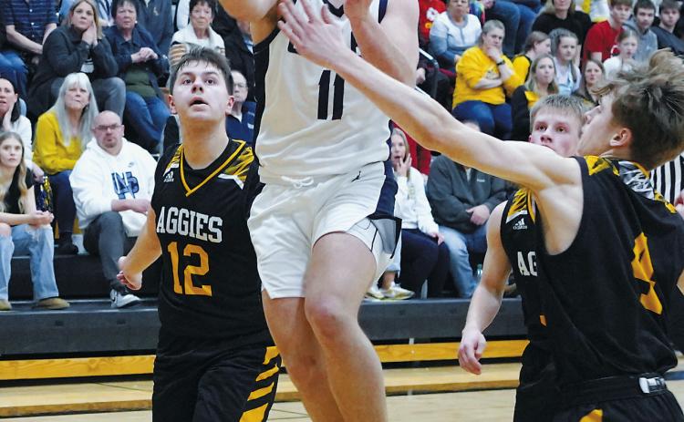 Grant Cosley eyes the basket, splits the Aggie defenders, and adds two points to the Eagles' score. Photo by Larry Stokke.