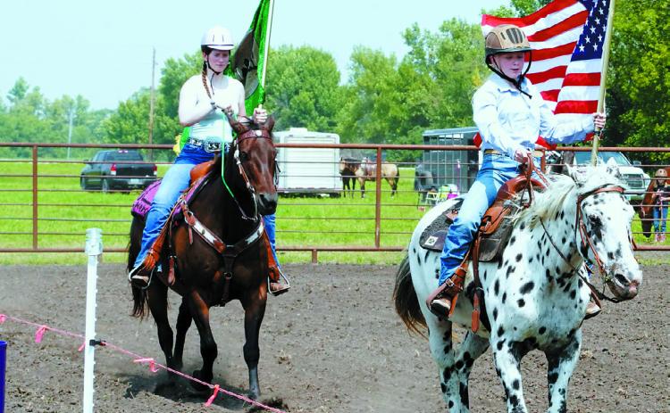 Carrying the American flag is Monica Bina on Dottie and following her is Ingrid Myrdal on Rudy. Photo by Larry Stokke.