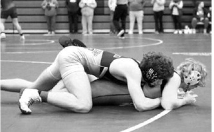 Bryce Carignan won his match by pinning his opponent and is heading to the State Meet. Photo by Larry Stokke