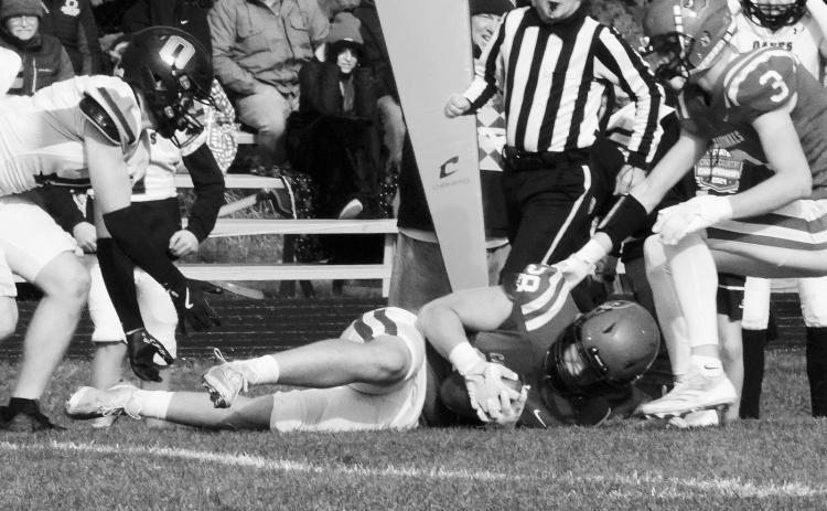Theo Romfo jumps on a loose ball in the Cards’ win over Oakes to advance to the next round of playoffs. Photo by Larry Stokke.