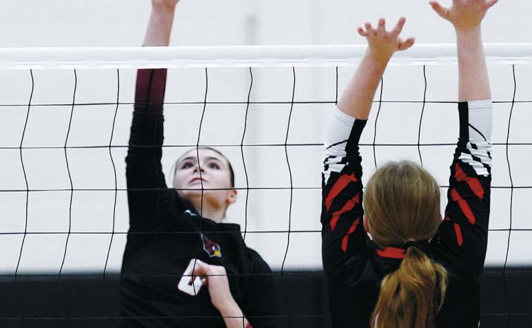 Taya Feist with one of her three kills, along with five blocks and six digs in the Cards' three set sweep of the North Star Bearcats. Photo by Larry Stokke.