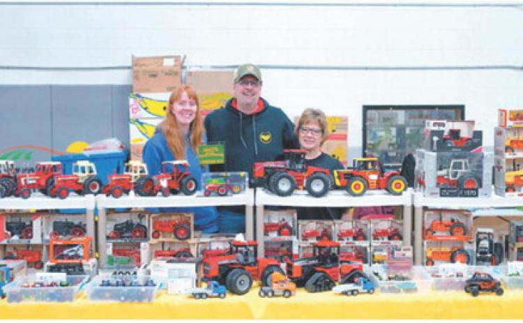 It’s a family affair at the Toy Show in Langdon: Daughter Jenny Schrader joins her parents, Mike and Connie Schrader, at their booth over the weekend after getting everything set up and ready for visitors. Photo by Larry Stokke