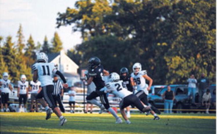 North Border’s Rhyder Girodat, No. 6, fights through a tackle during the Eagles’ season opener against the North Prairie Cougars on Friday, Aug. 21, in Pembina. Photo by Ashley Schafer