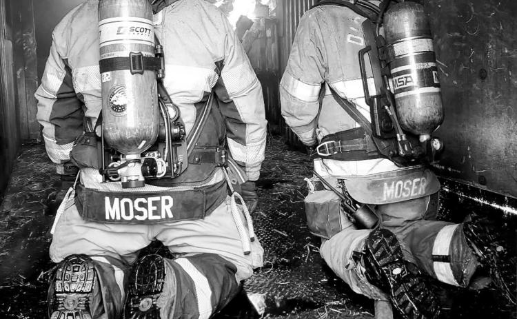Nick Moser, left, and his nephew, Hunter Moser, both nationally certified fire instructors, work together during structural live-fire training Aug. 8 in Cavalier. Firefighters from seven North Dakota communities participated in the exercise.