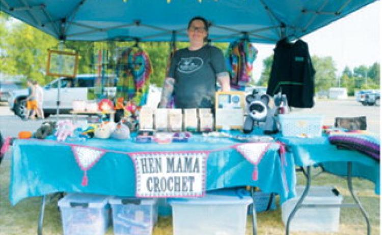 Hen Mama Crochet vendor displays colorful crocheted items, woven hot pads, beaded sun catchers and tie-dye clothing during the Walhalla Growers and Makers Market’s special night market Wednesday, Aug. 12. Photo by Larry Stokke
