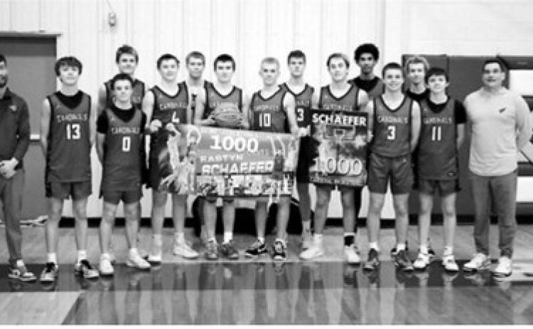 Sophomore Eastyn Schaefer celebrates 1,000 career points with his team after the Cards win against North Prairie on Feb. 9. Photo by Larry Stokke