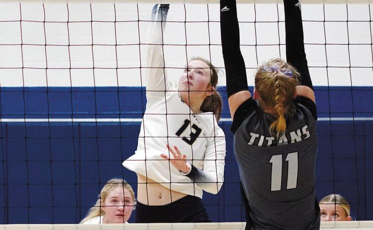 Addison Lyons sends the ball over a Titan for a point. Photo by Larry Stokke.