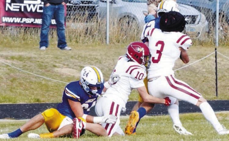 Cody Amble and Maddux Stremick wrap up the Aggie's Treyson Iglehart. Photo by Larry Stokke.