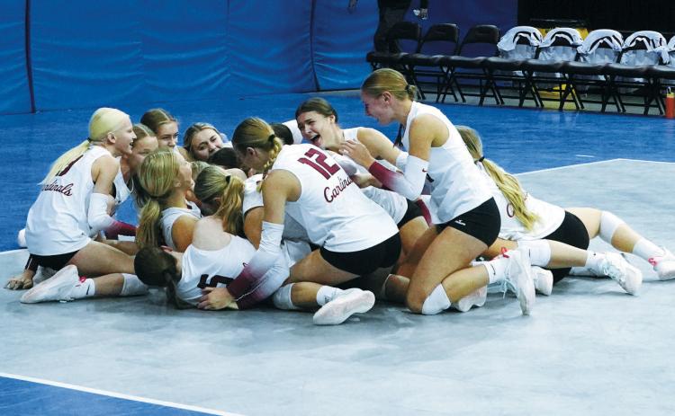 Overwhelmed with emotion, the 2024 Langdon Area-Munich volleyball team falls to the floor in celebration of their Class B State Championship win. Photo by Larry Stokke.