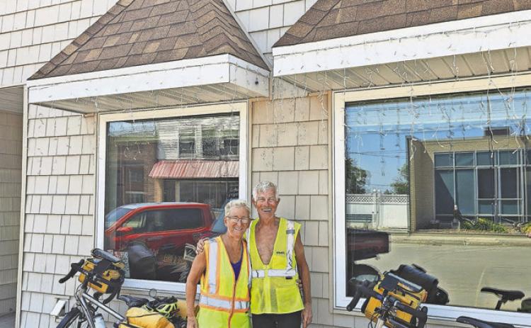 Ed Acheson and Michèle DeVoe stand in front of the Bread Pan with their cycling gear. PHOTO BY NICK VORLAGE