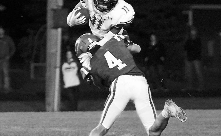 Sam Davis knocks wide receiver Joe Taylor off his feet to stop him from gaining any yardage. Photo by Larry Stokke.