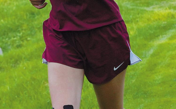 Chloe Foster leads a group of girls at the Larimore Meet. Photo by Larry Stokke.