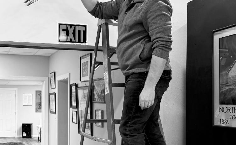 Clint Boyd, a senior paleontologist from Bismarck, installing the library’s new 4-foot scale of the Jormungandr Walhallaensis.