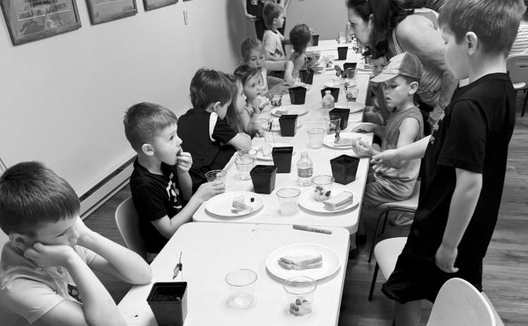 Kids planting pumpkin seeds after Story Hour last week.