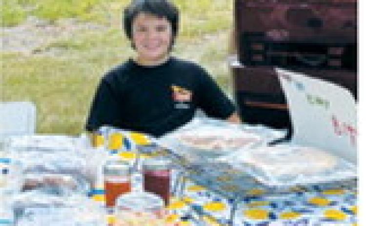 Bohdyn Hope displays homemade baked goods, jams and jellies from his business, Hope in Every Bite, at a local farmers market.