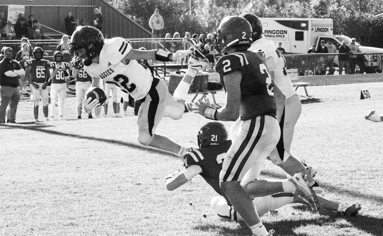 Eastyn Schaefer gets his hands on the Aggies Tucker Omdahl's legs and stops his forward progress. Photo by Larry Stokke.