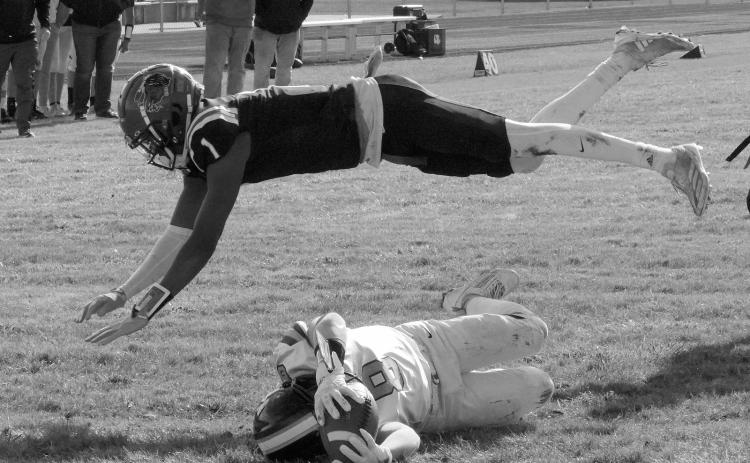 Four Wind's Marial Deng dives over Logan Werner as he crosses the goal line for a TD in the playin game. Photo by Larry Stokke.