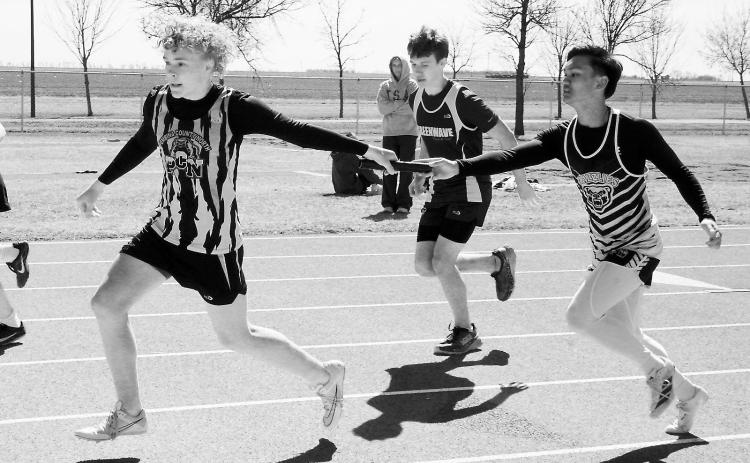 Lance Santiago hands off the baton to Kylan Schafer along with teammates Trevor Moore and Fletcher Kemp placed 8th in the 4x200 relay. Photo by Larry Stokke.