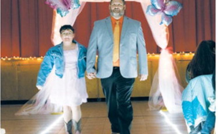 Nadiya and her father, Nyk Hope, are announced and walk down the runway during the Butterfly Ball held April 17 in Langdon. The event raised funds for the Cavalier County Cancer Crusaders. Photo by Katie Polansky Photography.
