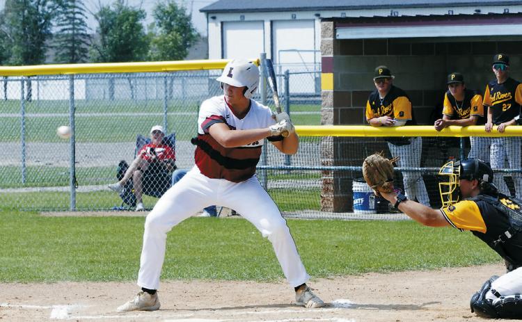 Landon Schneider eyes the ball before launching it into the outfield. Photo by Larry Stokke.