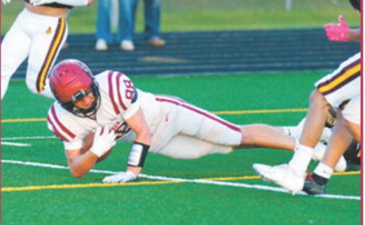 Langdon Area-Munich’s Colten Hein, No. 88, holds onto the ball as he is brought down during the Cardinals’ Sept. 11 game against Turtle Mountain in Belcourt. Photo by Larry Stokke