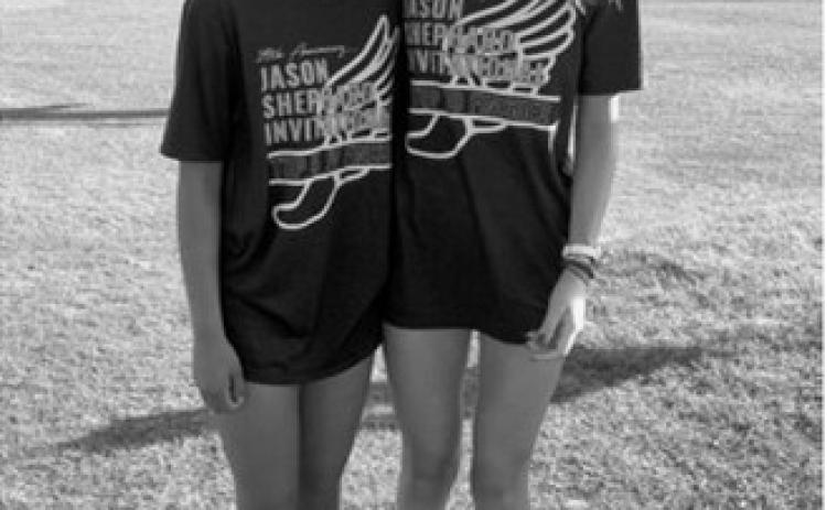 Aishu Chapara, left, and Olivia Lorenz show off their T-shirts after each placed fifth at the Jason Shephard Invitational in Cavalier. Chapara finished fifth in the junior varsity girls race, while Lorenz placed fifth in the varsity girls race. Submitted photo