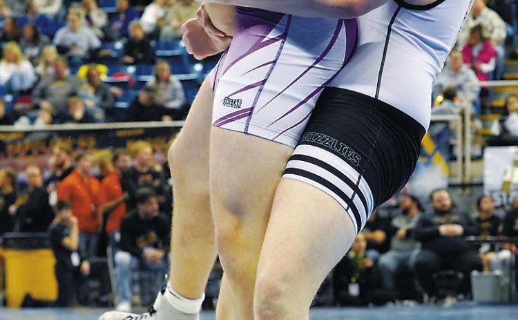Denton Kaercher powers his man up in the air and takes him to the mat at the State Wrestling Meet. Photo by Larry Stokke.