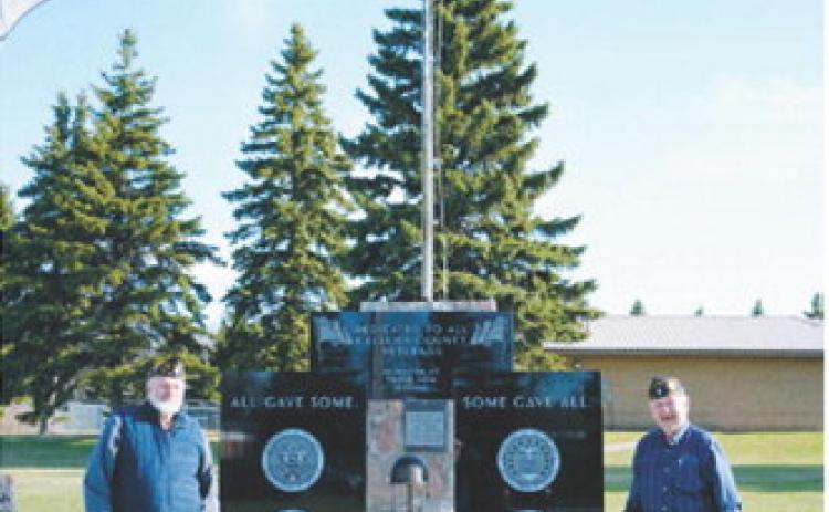 Fellow Post 98 members Bob MacDonald (left) and Harvey Metzger (right) stand in front of the new monument. Photo by Larry Stokke