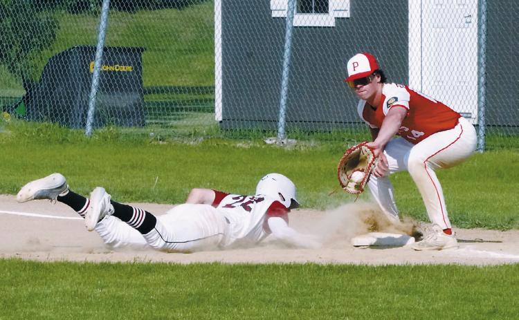 Mason Romfo slides back to first base against MayPort. Photo by Larry Stokke.