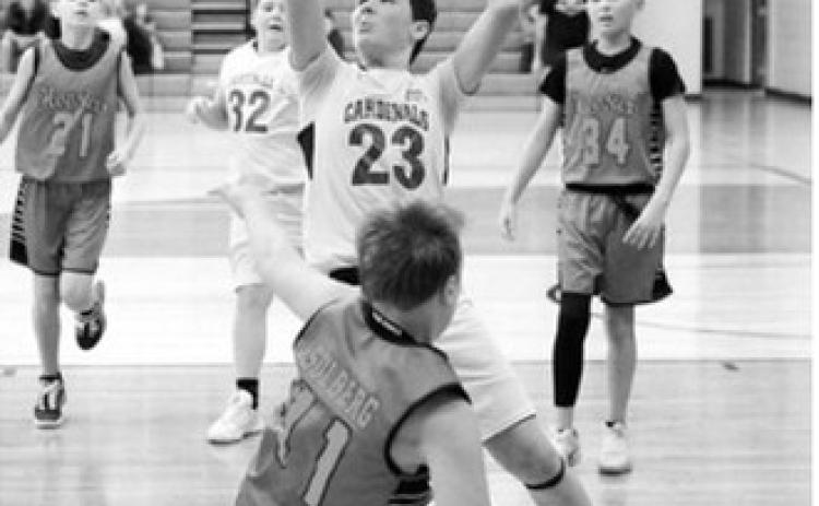 Kyler Hansen drives to the basket and adds two points to the Cards score at the Sports Boosters Tournament in Langdon on Jan. 24. Photo by Larry Stokke
