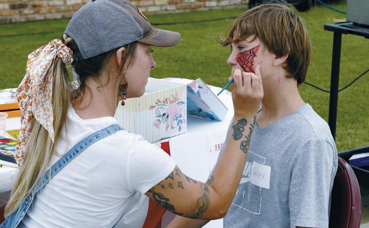 A volunteer gets his face painted SPIDERMAN-style at the Maple Manor Carnival. Photo by Larry Stokke.