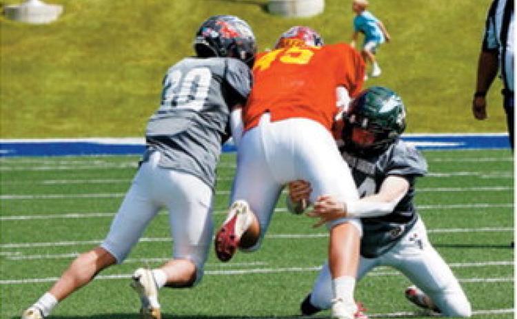 Brody Berg and a teammate bring down a West nine-man team ball carrier during the Shrine Bowl on June 20. Photo by Larry Stokke