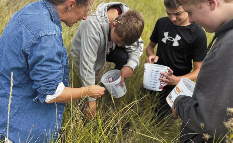 Artist Austen Camille [left] along with North Valley CTE students Aaron Linner, Kale Tanke, and James Elliott collecting prairie soils they later rendered into paint pigments during the Thinking Like a Prairie workshops. Photo provided by Josh Anderson.