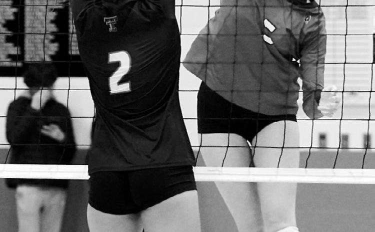Hallie Overby sends the ball over a Tommies player for a point. Photo by Larry Stokke.