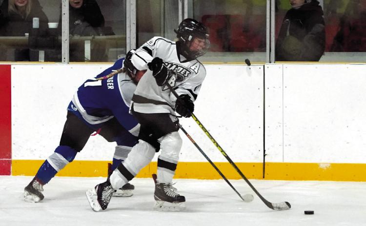 Mckenzie Regner brings the puck up the ice while under pressure from a a Bruiskie player. Photo by Larry Stokke.
