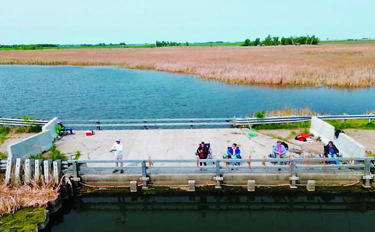 The Nowatzki ‘kids’ set up chairs and rod holders on old 281 near Churchs Ferry for their frequent fishing trips to Devils Lake. There were 11 children in the family and all loved to fish. The oldest is now 87. Photo by Abby Makay / WDAY News.
