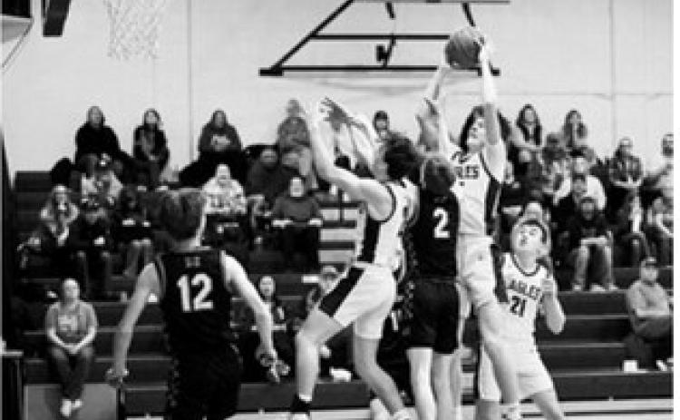 Garret rises above defenders to snag the offensive rebound. Photo by Ashley Schafer