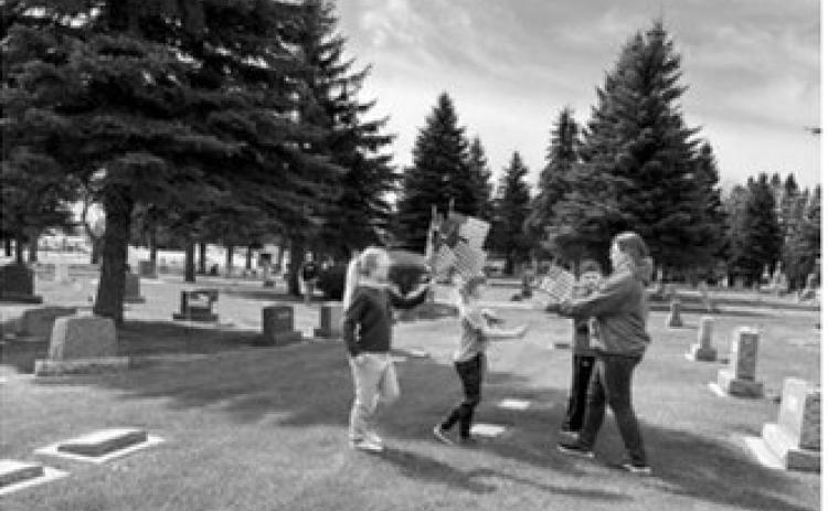 Members of the Prairie Rose 4-H Club, their families and veterans from the Langdon American Legion gathered before placing flags at area cemeteries in preparation for Memorial Day observances. Volunteers assisted with the annual effort to honor veterans and show respect for those who served their country.