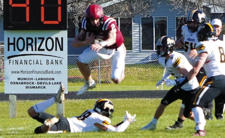 Jax Johnson hurdles over a Jaguar defender to add to his 128-yard rushing day. Photo by Larry Stokke.